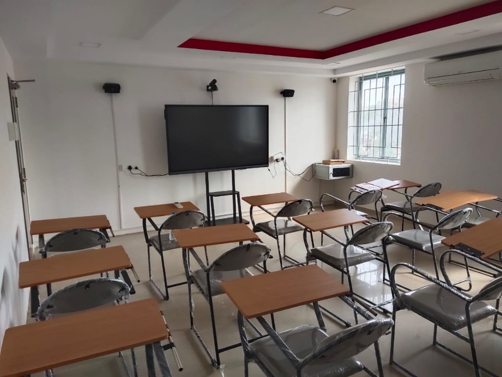 A modern empty classroom equipped with a smart board and desk setups at Fly Air Aviation Academy
